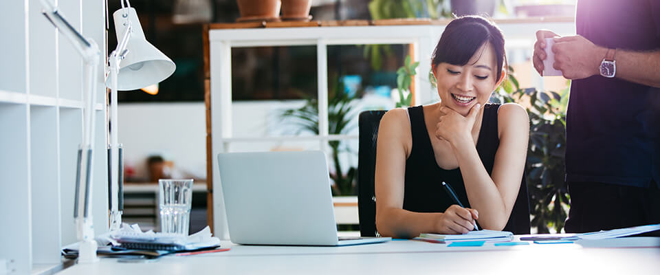 Business woman working with colleague at desk