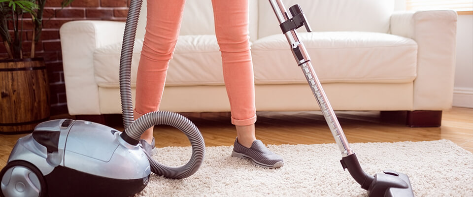 Woman hoovering rug