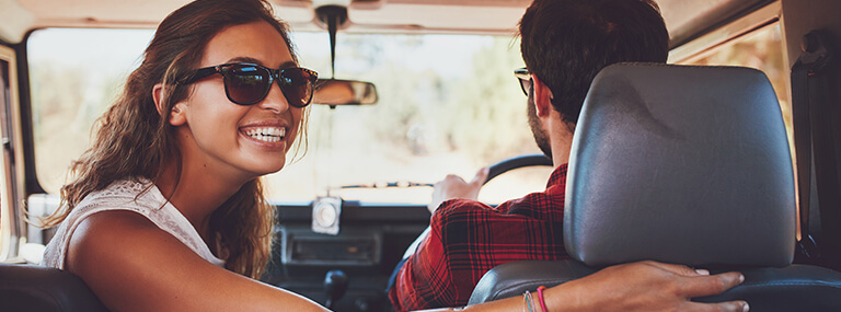 Woman with glasses smiling in car